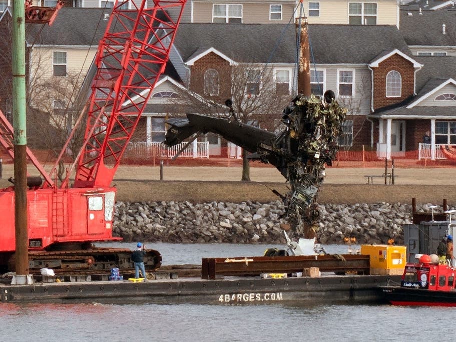 Rescue and salvage crews pull up a part of an Army Black Hawk helicopter that collided midair with an American Airlines jet at Ronald Reagan Washington National Airport in January 2025.