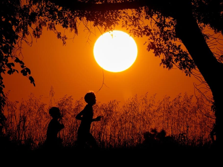 People are silhouetted against the sky at sunset as they run at Shawnee Mission Park, Sept. 26, 2024, in Shawnee, Kansas.