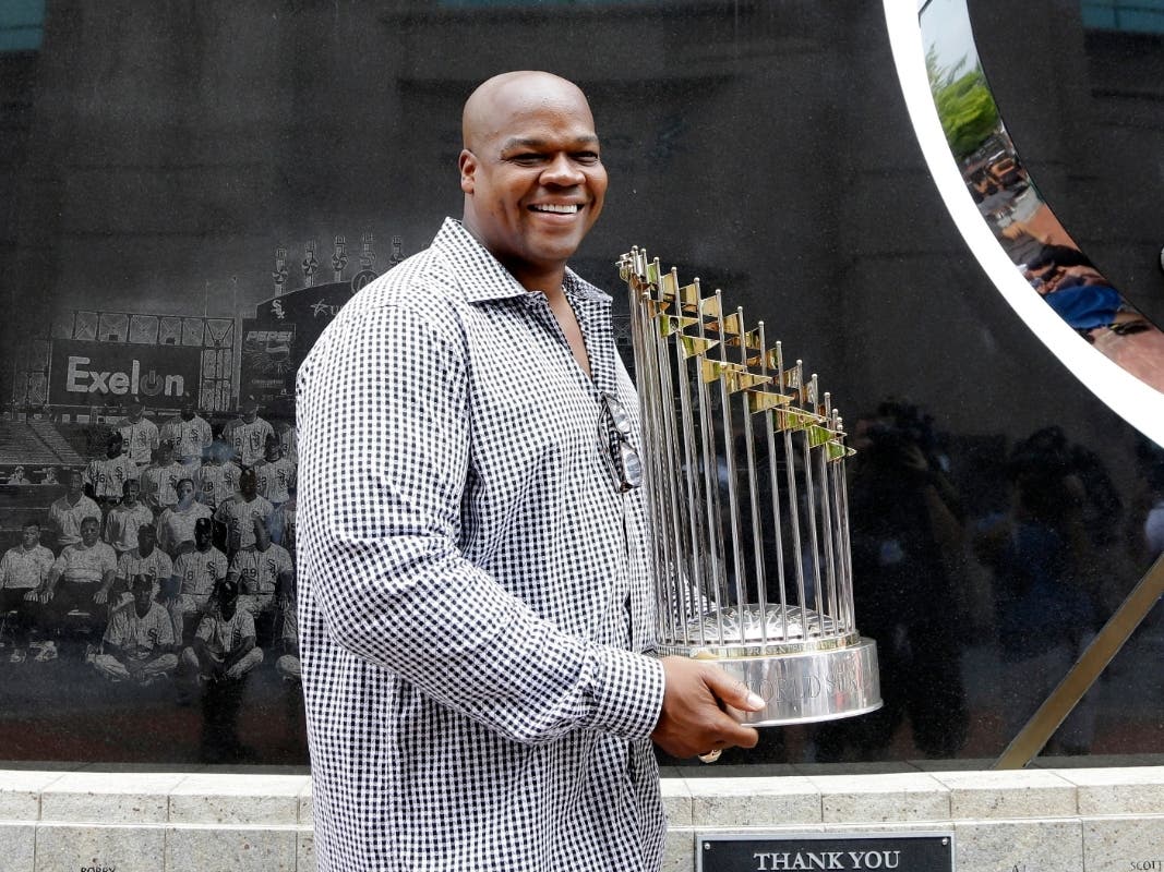 Former Chicago White Sox player and Hall of Famer Frank Thomas holds the 2005 World Series Champion trophy before a baseball game between the Kansas City Royals and the Chicago White Sox in 2015. Now he's suing the team.