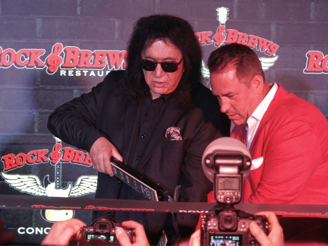 In this image taken from video, KISS frontman Gene Simmons appears with co-franchise owner Danny Yezbick at a ribbon-cutting ceremony for Rock & Brews restaurant in Royal Oak, Mich., on Thursday.