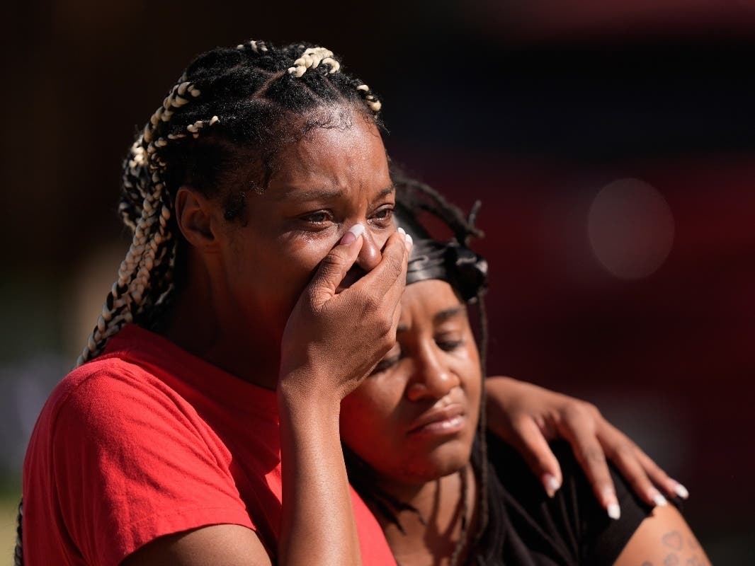People grieve as they comfort each other outside the scene of a mass shooting, Sunday, April 19, 2026, in Shreveport, La.