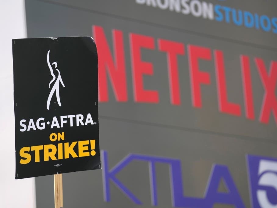 A picketer carries a sign on the picket line outside Netflix on Wednesday, Sept. 27, 2023, in Los Angeles. 