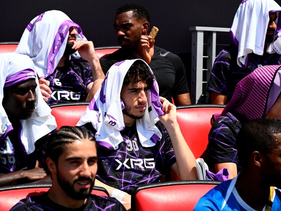 Al Ain's Hazim Abbas, center, shields himself from the sun with other players before the Club World Cup Group G soccer match between Wydad AC and Al Ain FC in Washington, June 26, 2025. 