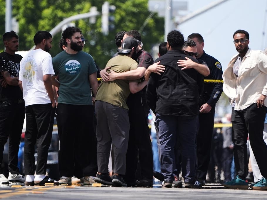 People embrace near the scene of a shooting outside the Islamic Center of San Diego Monday, May 18, 2026, in San Diego.