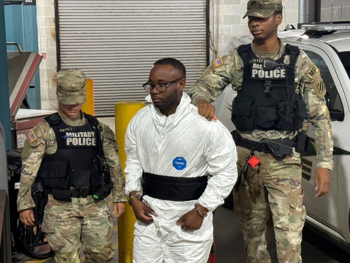 Sgt. Quornelius Radford, center, is escorted by military police into a booking room at the Liberty County Jail in Hinesville, Ga., Aug. 6, 2025.