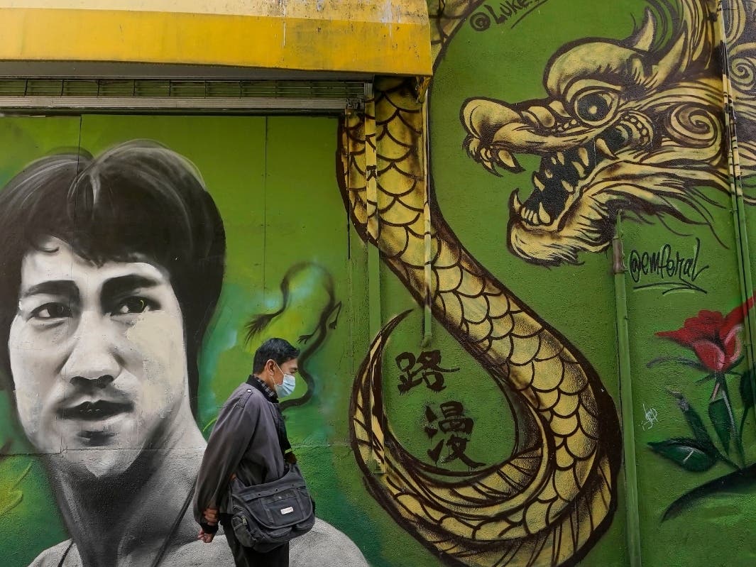 A man walks past a mural showing Bruce Lee and a dragon in San Francisco, Dec. 30, 2020.