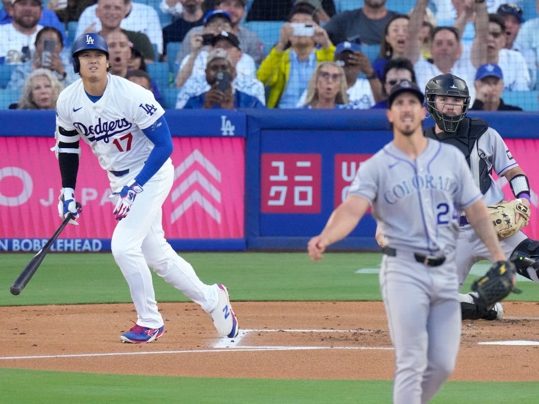 Los Angeles Dodgers' Shohei Ohtani, left, heads to first for a solo home run as Colorado Rockies starting pitcher Michael Lorenzen, center, and catcher Braxton Fulford watch during the first inning of a baseball game Tuesday, July 7, 2026, in Los Angeles.