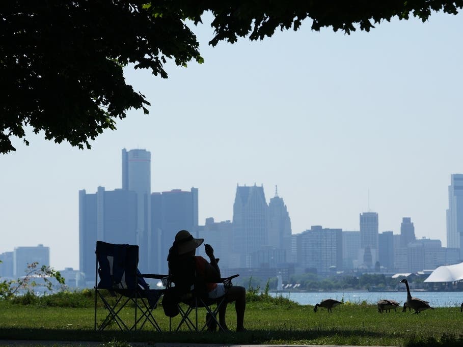 A woman sits in the shade to avoid the heat Monday in Detroit. 

