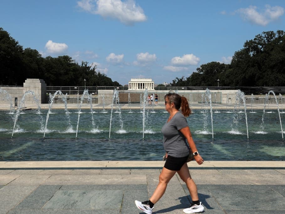 A woman walks near the fountain at the WWII Memorial in Washington on Wednesday, July 29, 2026.