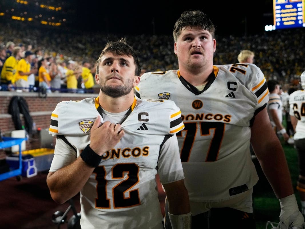 Western Michigan quarterback Broc Lowry (12) and Hunter Whitenack (77) watch from the bench at the end of the second half of an NCAA college football game against Michigan Saturday in Ann Arbor.
