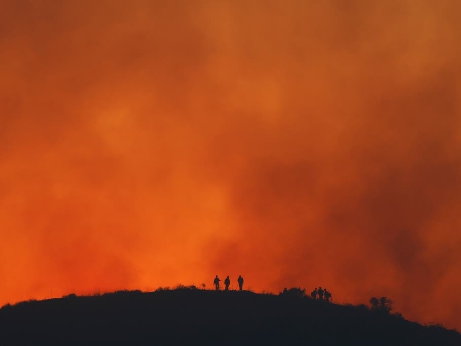 Firefighters are silhouetted amid an operation to control the Sandy Fire, May 19, 2026, in Simi Valley, Calif. California’s Fifth Climate Change Assessment was released this week.