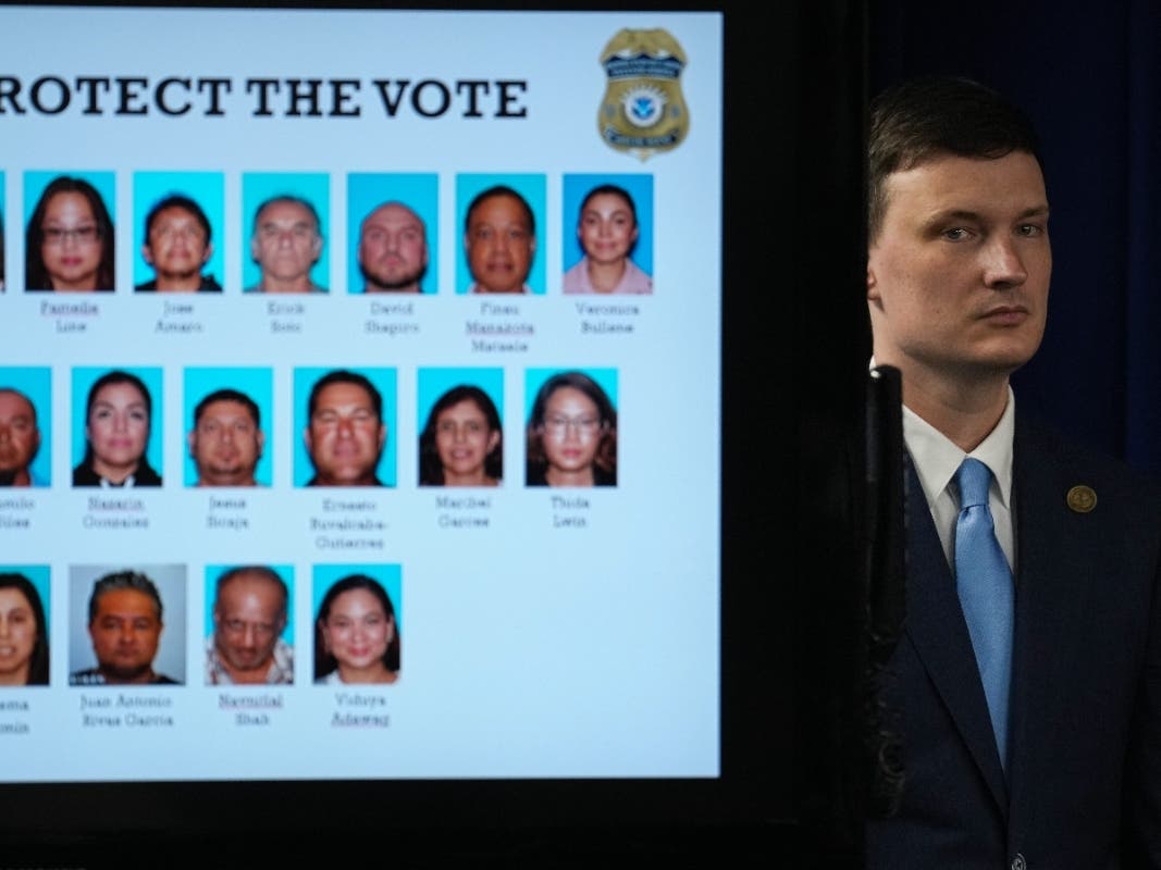 Acting U.S. Deputy Attorney General Trent McCotter stands next to a display showing photos of people charged with illegally registering to vote during a news conference in Los Angeles, Monday, Oct. 19, 2026. 