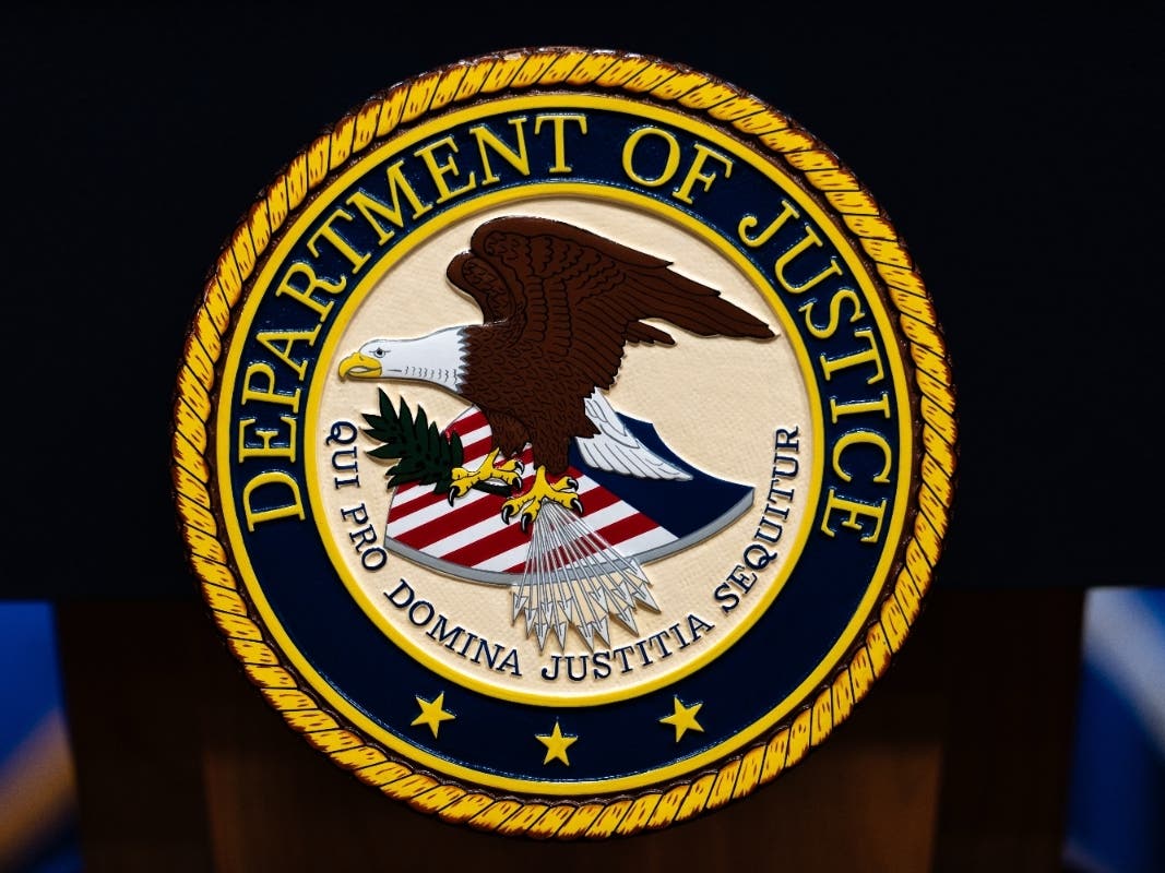 The U.S. Department of Justice logo is seen on a podium before a news conference, May 4, 2026, in Washington