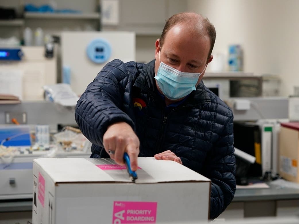 Gov. Jared Polis opens the state's first shipment of COVID-19 vaccine Dec. 14 at the Colorado Department of Public Health and Environment. The governor expressed frustration Friday after he said the federal government backtracked on its vaccine plan.