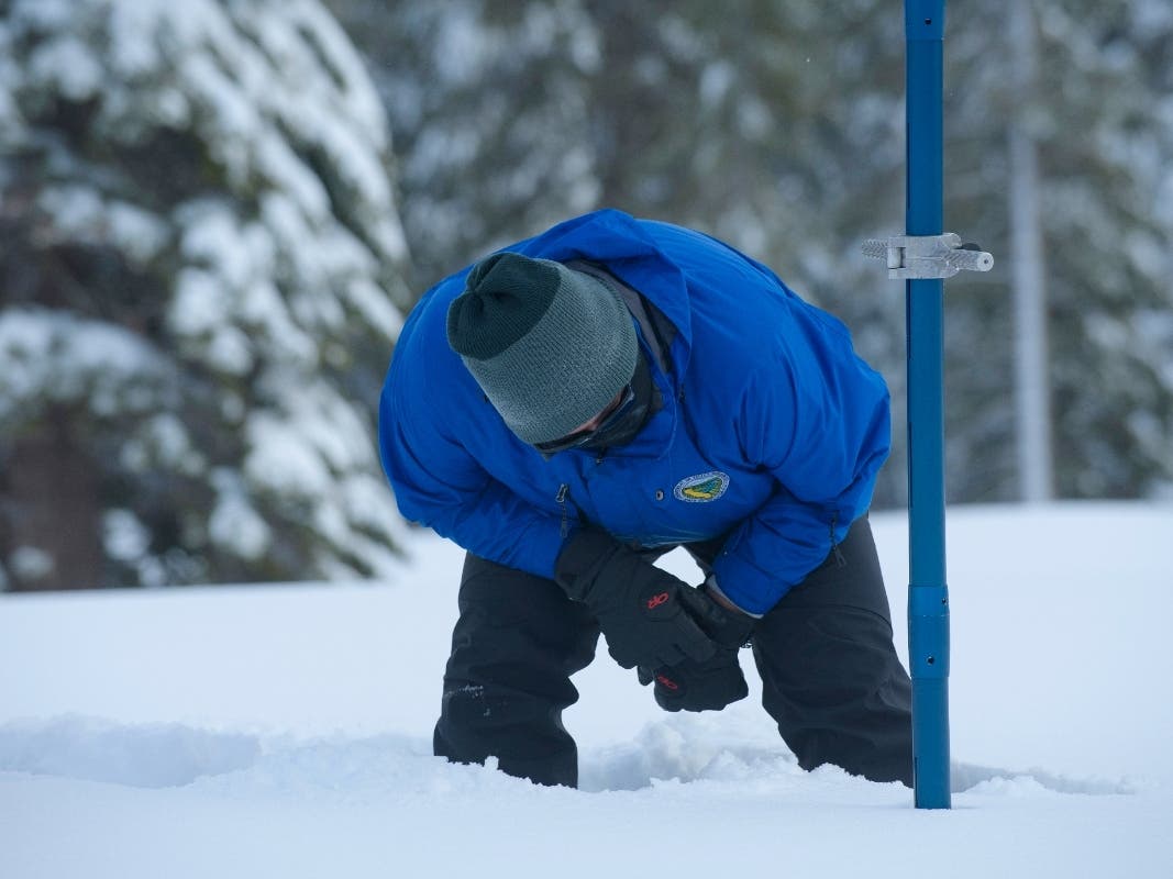 Sean de Guzman, chief of snow surveys for the California Department of Water Resources, checks the depth of the snow pack during the first snow survey of the season at Phillips Station near Echo Summit, California.
