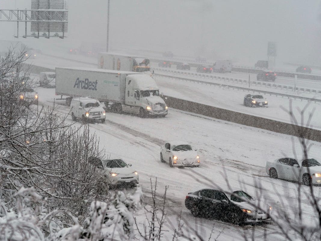 Traffic slips going up a small hill on I-495, the Capital Beltway, as snow falls, Monday, January 3, 2022, in Fort Washington, Maryland.