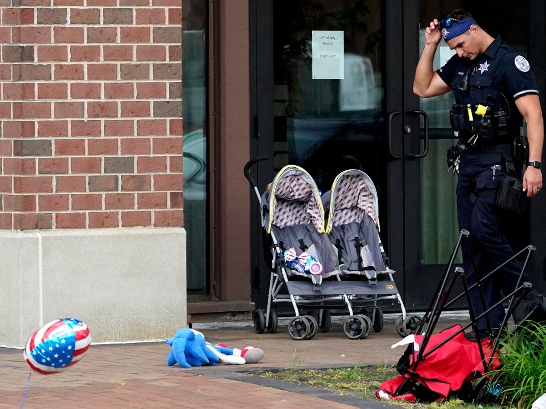 A police officer reacts as he walks in downtown Highland Park, a suburb of Chicago, on Monday, where a mass shooting took place at a Highland Park Fourth of July parade. 
