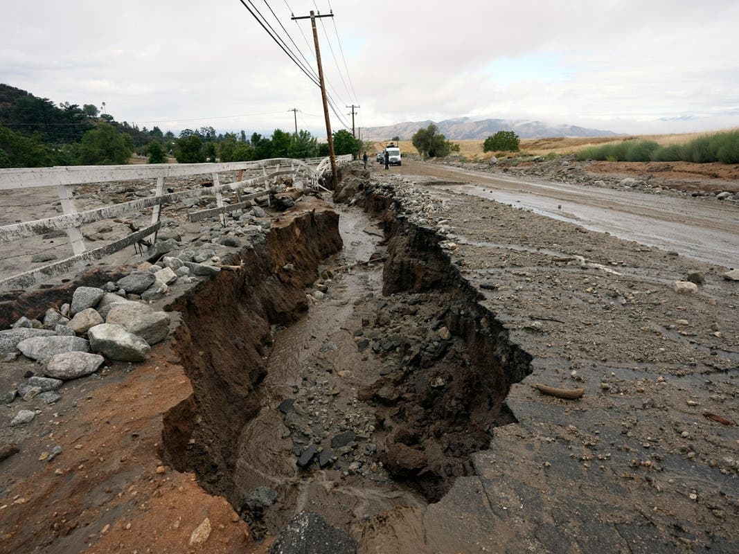 Mud and water flow through a crack off the side of the road in the aftermath of Tropical Storm Hilary, Monday, August 21, 2023, in Yucaipa, California. 
