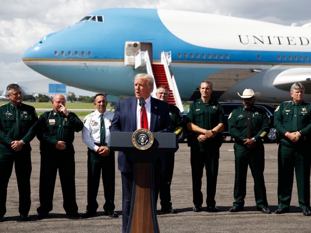 With Air Force One in the background, President Donald Trump speaks Tampa International Airport during a campaign event with the Florida Sheriffs Association in Tampa Friday.