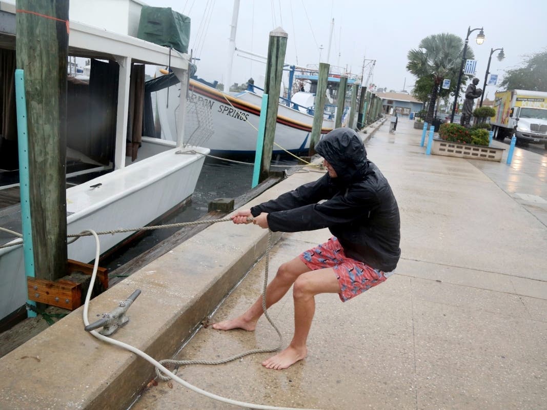 Sponge diver Alan Fox, 16, of Tarpon Springs, slacks the lines Wednesday on his sponge boat at the Tarpon Springs Sponge Docks in preparation for Tropical Storm Eta.