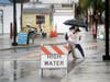 Petra Gringrich, left, and Maria Gomez, both of Tampa, cross a rain soaked Dodecanese Boulevard in downtown Tarpon Springs Wednesday. 