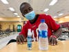 David Green sits with a bottle of water and hand sanitizer, provided at an emergency shelter set up due to Tropical Storm Eta at Middleton High School Wednesday in Tampa. 