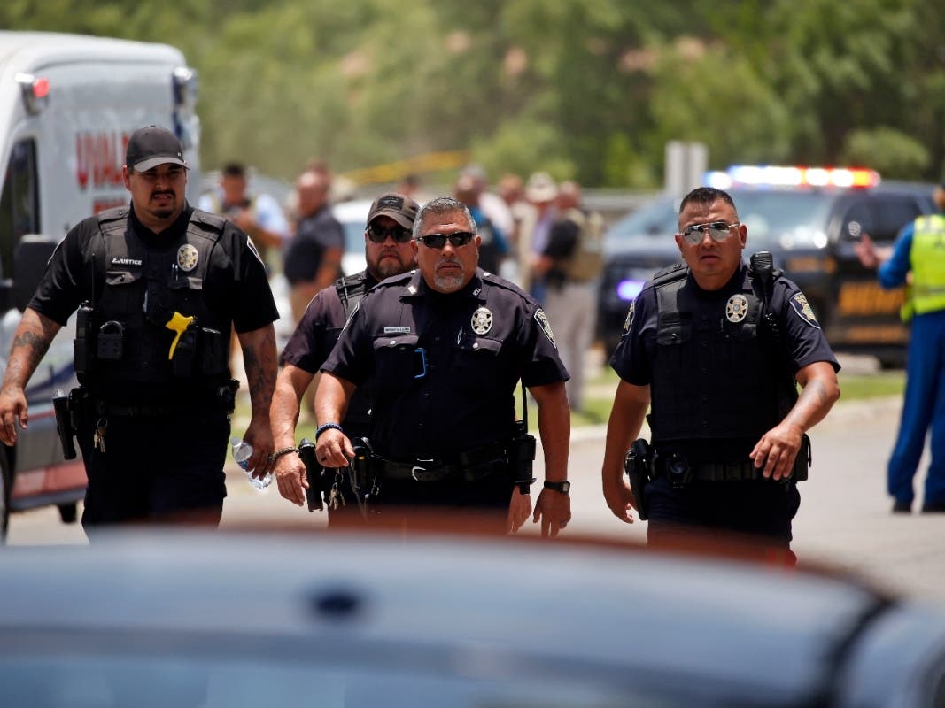 Police walk near Robb Elementary School following the shooting on Tuesday, May 24, 2022, in Uvalde, Texas.