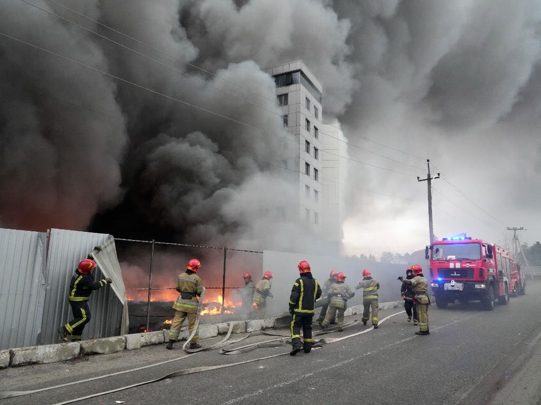 Firefighters work to extinguish a fire at a damaged logistic center after shelling in Kyiv, Ukraine, Thursday, March 3, 2022. Russian forces have escalated their attacks on crowded cities in what Ukraine's leader called a blatant campaign of terror.