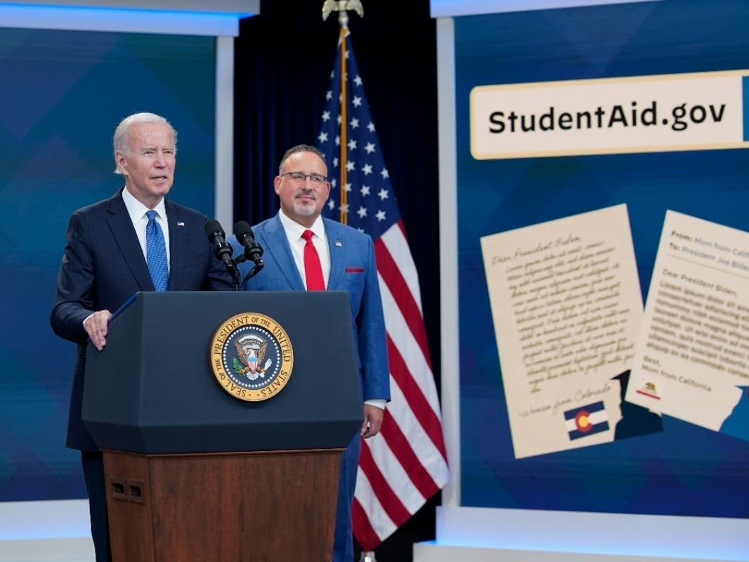 President Joe Biden speaks about the student debt relief portal beta test as Education Secretary Miguel Cardona listens in the South Court Auditorium on the White House complex in Washington, Monday, Oct. 17, 2022.