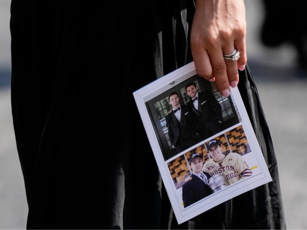 A mourner departs while holding a program following the funeral for Columbus Blue Jackets hockey player John Gaudreau and his brother Matthew Gaudreau at St. Mary Magdalen Catholic Church in Media, Pa., Monday, Sept. 9, 2024.