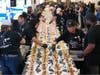 Volunteers assemble cheesesteaks in a Guinness World Record attempt on National Cheesesteak Day at Philadelphia International Airport, Tuesday, March 24, 2026, in Philadelphia.