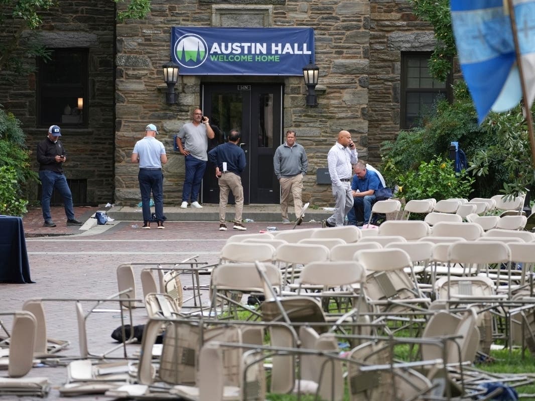 People use there phones in a mess of toppled chairs at the Villanova University campus where an active shooter was reported Thursday, Aug. 21, 2025, in Villanova, Pa.