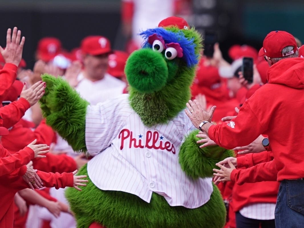 FILE - The Phillie Phanatic, the Philadelphia Phillies mascot, leads the team onto the field ahead for their home-opener baseball game against the Colorado Rockies, Monday, March 31, 2025, in Philadelphia.