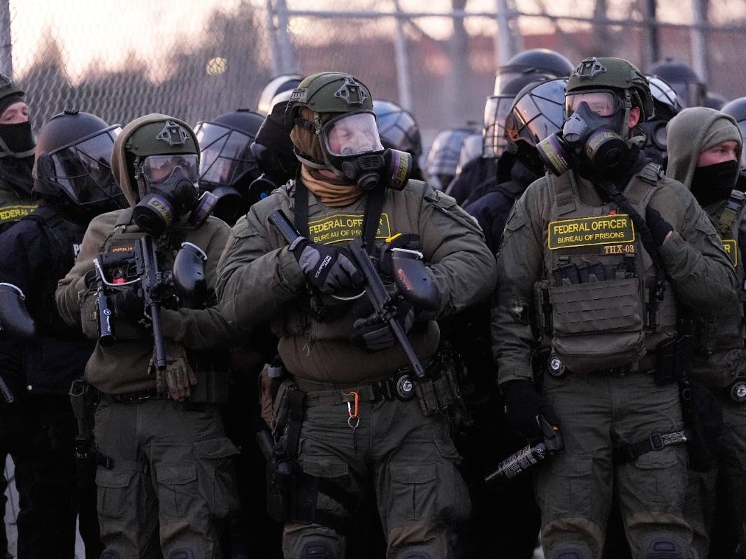 Federal officers stand outside the Bishop Henry Whipple Federal Building during a protest on Saturday, Jan. 17, 2026, in Minneapolis.