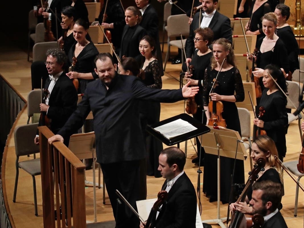 In this Oct. 31, 2019, file photo, Andris Nelsons gestures towards the musicians prior to conducting a joint concert of the Boston Symphony Orchestra and Germany's visiting Leipzig Gewandhaus Orchestra, at Symphony Hall, in Boston..