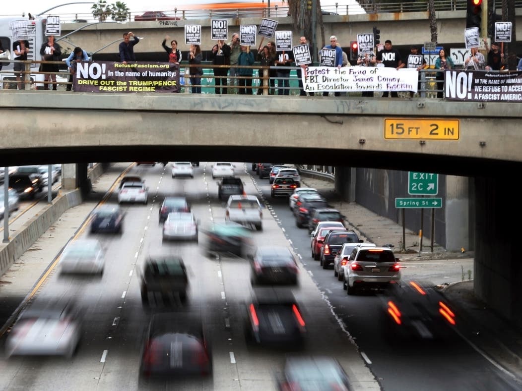 After a protest at the nearby downtown Los Angeles federal building, members of a group calling itself Refuse Fascism attract the attention of motorists Wednesday, May 10, 2017, as they protest.