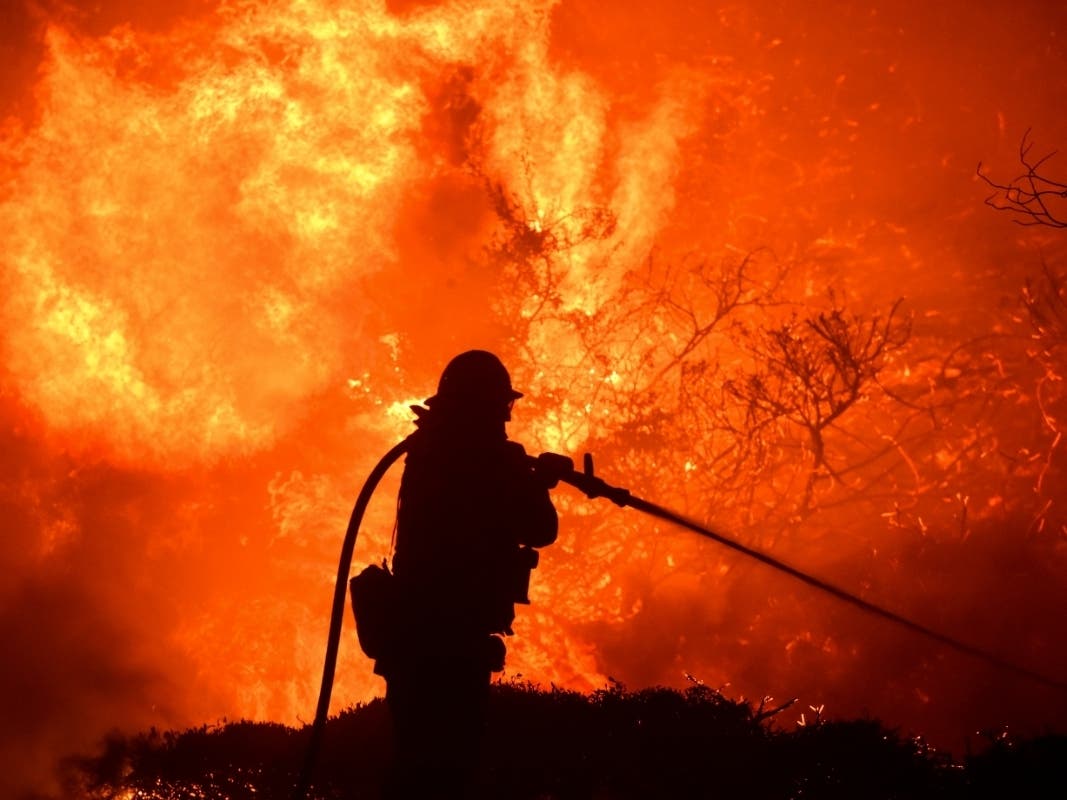 The Saddleridge fire flares up near a firefighter in Sylmar, Calif., Thursday, Oct. 10, 2019.