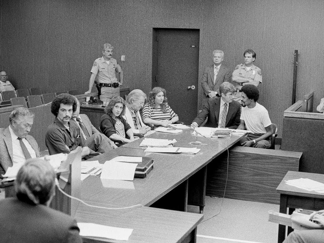 Four persons charged in connection with the June 2 fatal shooting of the Los Angeles police officer Paul Verna sit with their attorneys during a preliminary hearing in a San Fernando court room, Aug. 22, 1983.