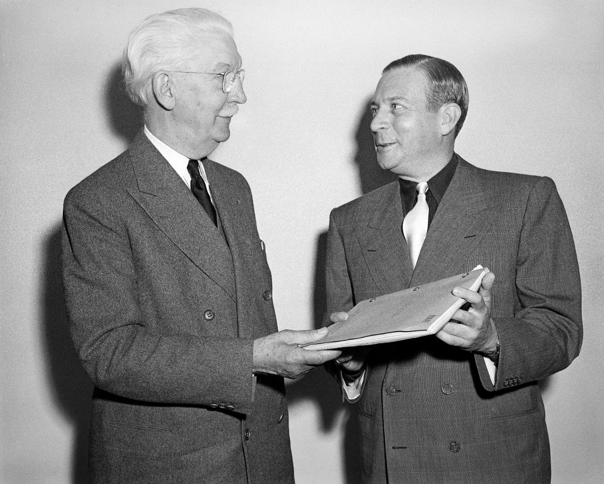 Chancellor Rufus B. von KleinSmid, left, of the University of Southern California, accepts a script of "The Killers" from Universal Pictures producer Mark Hellinger,. 