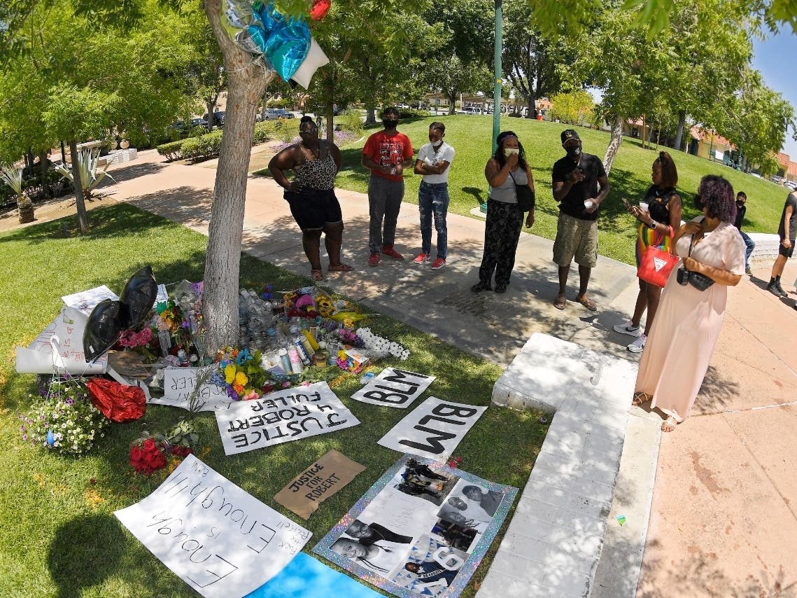 People look at a memorial as they gather near the site where Robert Fuller was found hanged, Monday, June 15, 2020, in Palmdale,  federal authorities will monitor the investigation into the death of Fuller, a black man found hanging from a tree.