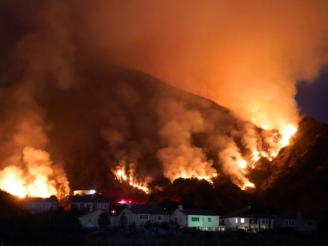 The Ranch Fire burns over a residential area, Thursday, Aug. 13, 2020, in Azusa, Calif. Heat wave conditions were making difficult work for fire crews battling brush fires and wildfires across Southern California.