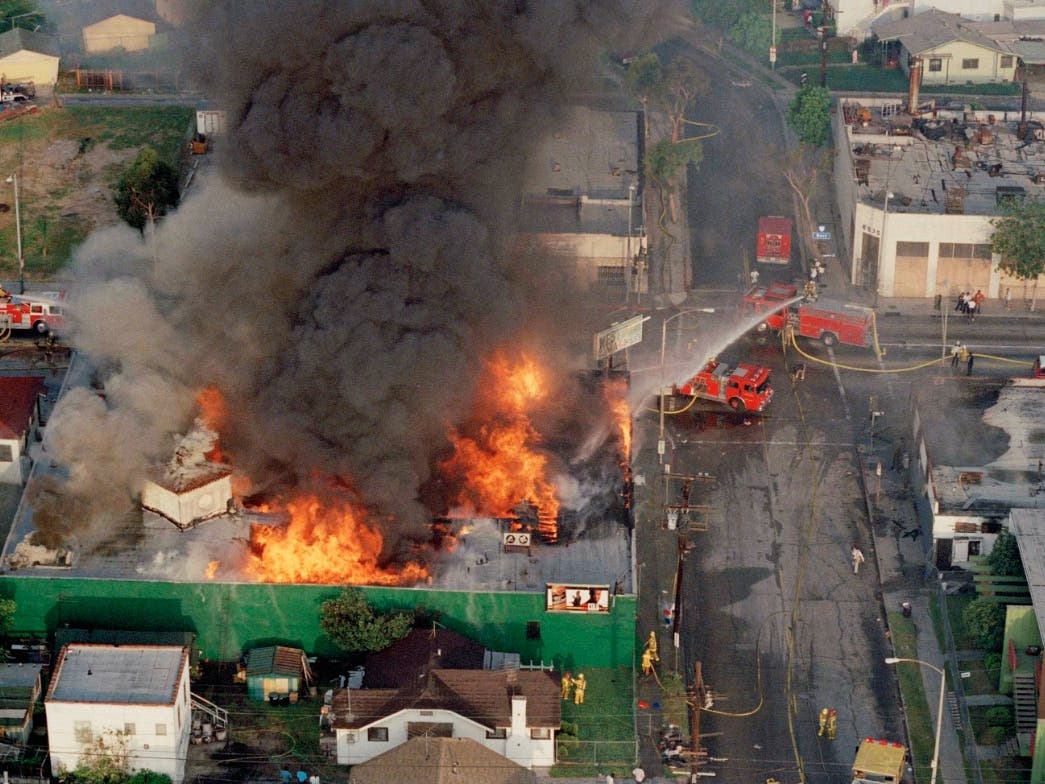 A fire burns out of control at the corner of 67th Street and West Boulevard in South Central Los Angeles, on April 30, 1992. 