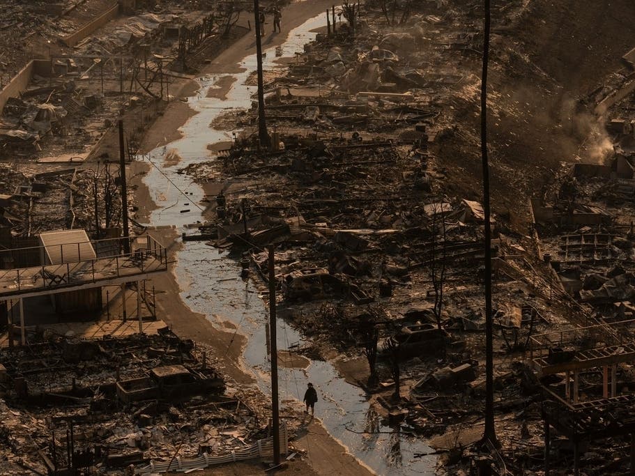 A person walks amid the destruction left behind by the Palisades Fire on Jan. 9, 2025.
