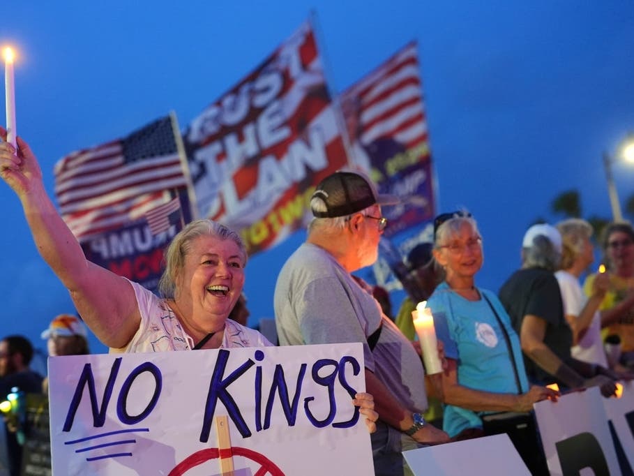 Dee Cahill of Margate, Fla., holds a "No Kings" sign as she participates in a pro-democracy, anti-Trump protest outside Trump's Mar-a-Lago estate in Palm Beach, Fla., as part of the "Good Trouble Lives On" national day of action, July 17, 2025.