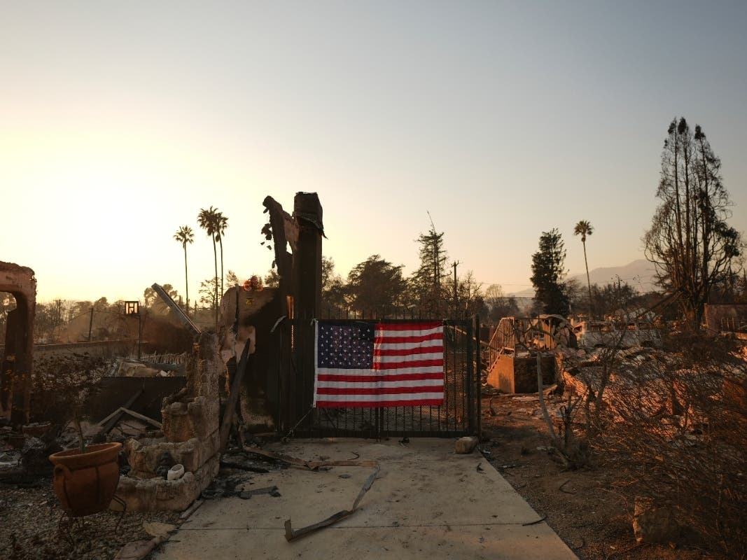 An American flag hangs on the gate of a home destroyed by the Eaton Fire in Altadena, Calif., Jan. 10, 2025. 