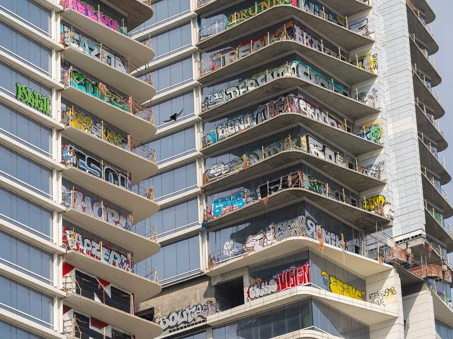 The unfinished Oceanwide Plaza towers stand across from LA Live in downtown Los Angeles in February 2024. Clean up of graffiti was expected to be complete by this fall.