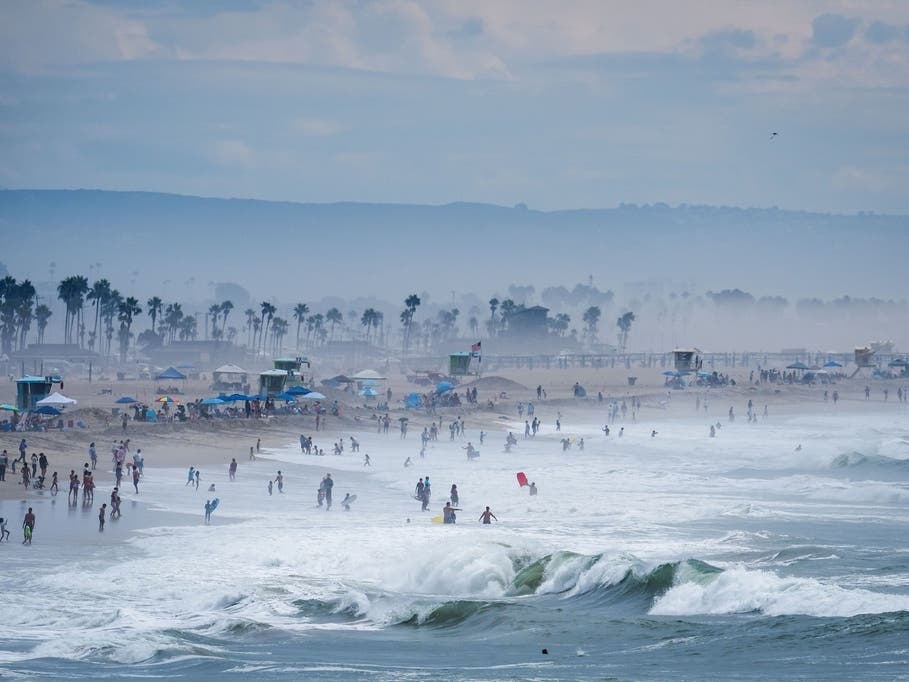 Beachgoers stand in thick humidity as large waves from Hurricane Marie break on the shore, Monday, Sept. 7, 2026, on Huntington Beach, Southern Calif.