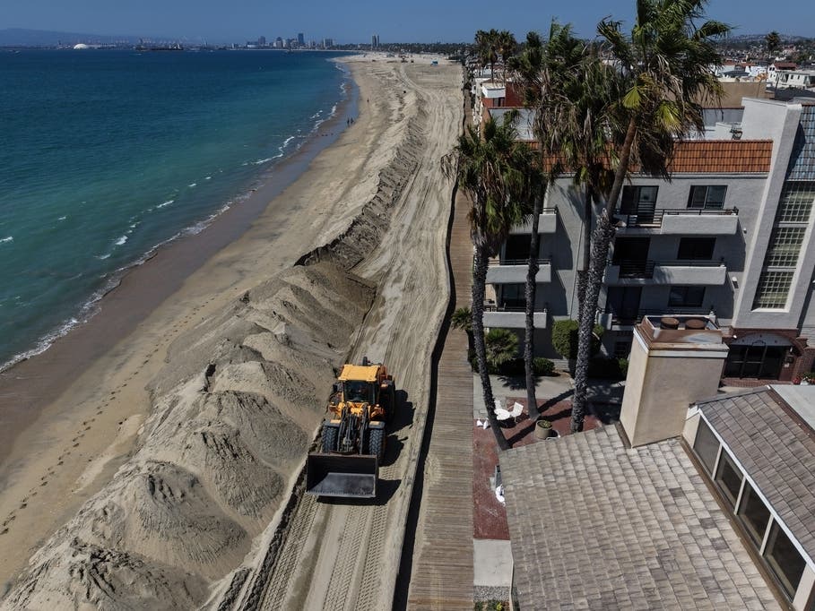 Heavy machinery builds up a sand berm along the beach to protect homes ahead of the upcoming storm season in Long Beach, Calif., Wednesday, Sept. 23, 2026.