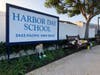 Flowers and messages are placed in front of Harbor Day School, a private elementary school in Corona Del Mar, Calif., Monday, Jan. 27, 2020. Christina Mauser, a girls basketball coach at the school, was among those killed in the helicopter crash.