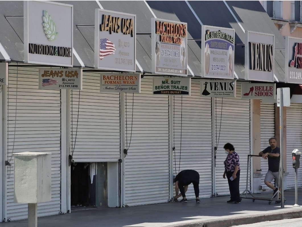 Merchants close a store Monday, May 4, 2020, in the fashion district of Los Angeles.